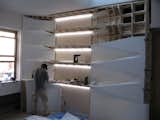 Midway through the installation, a builder inset LED lighting strips in the center section of the Corian and plywood unit.