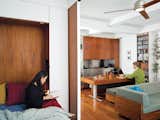 Screened by the sliding door, Rosa cozies up with a book in the bedroom, while across the apartment Robert uses the hydraulic kitchen table as a work desk. “We wanted to explore the power of custom design by creating integrated furniture to maximize both efficiency and aesthetics,” says Rosa.