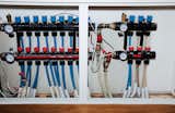 The radiant-heating system's pipes and gauges hide in a closet.