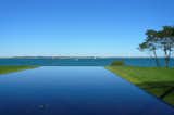 On one side of the house, a reflecting pool with an infinity edge seems to run right into the ocean.  Photo 8 of 29 in Visiting the Fishers Island House by Jaime Gillin
