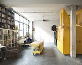 The five roommates share the common space in their high-ceiling loft. There’s a large library and a studio. The large worktable gives Dreitlein and Ionescu, who together have a small art/architecture practice called The Objectionists, space to paint and make models.