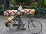 Not sure how he's going to ride his bicycle with two rolled-up Kala rugs, but....