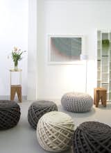 The shop's best-selling 'Urchin Poufs,' by Dutch-based Christien Meindertsma, are knit with gigantic needles. In the foreground are Meindertsma's Texelaar Ottoman Poufs. The wooden Backenzahn stools are by Phillip Mainzer for e15 and the ink-on-paper drawing, titled '5,604 Lines,' is by the San Francisco-based artist Alex Zecca.