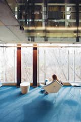 A student reads in a space below the library while lounging in George Nelson's Coconut chair, positioned next to Harry Bertoia’s Diamond chair.