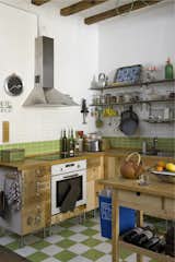 The kitchen cupboards were crafted from recycled wooden wine boxes, and the countertop is untreated wood certified by the Forest Stewardship Council (FSC) from Ikea. The green-and-white tiles are from a local company, TAU Cerámica.