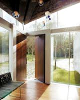 While most homes have their front doors centered on a flat wall, this home in Canada by Omer Arbel is entered through two solid walnut doors at the corner of the home.