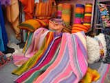A trove of yet more vibrantly colored rugs, pillows, and blankets.