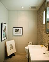 No room in the house is free from Jacobson's keen curatorial eye. The office bathroom is adorned with an original Glen E. Friedman image of skate legend Tony Alva (across from toilet) and a picture of Nathan Fletcher by Mark Oblow (adjacent). Framed on the floor is a George Condo illustration.  Photo 15 of 18 in Less is More in this Manhattan Beach Bungalow