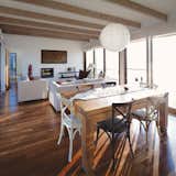 Dining Room, Pendant Lighting, Table, Chair, and Medium Hardwood Floor Light floods the living and dining rooms, meaning Schneider rarely needs to turn on a lamp during the day.  Search “natural habitats” from Tunquen Treasure