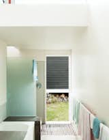 A bathroom with corrugated steel walls opens directly to the outdoors, making it easy to shower post-beach.