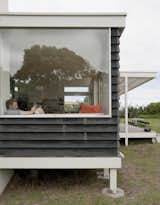 The glassy pavilion containing kitchen, dining, and living areas is elevated three feet off the ground on posts so it appears to hover among the dunes.
