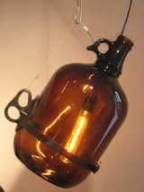 A close-up of a McMasterpiece pendant lamp by David Weeks, made with a tubular incandescent bulb and a glass jug.
