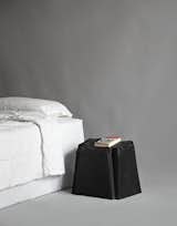 To create this bedside table, musician Michael Stipe cast the underside of his "cheap plastic chair" in a semi-soft, durable plastic typically used to make pickup truck bed liners.