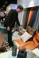 Here's Christopher laying out the fabrics for the pricier option... I'm smitten with the buttery camel-colored leather. The cowhide, shiny shag rug, and upholstered pillows less so.