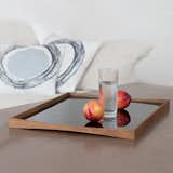 Architect Finn Juhl designed predominantly in the 1940s and 50s and created the TurningTray in 1956 to match the furniture in his house. The curvature of the teak eliminates the need for handles and the two sides—one laminated in black and the other in either red, white, light green, or pale blue—let it transition from day to evening use.