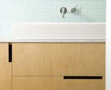 Open rectangular cutouts in modern wood cabinetry were the way to go in this bathroom vanity.