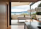 The north-facing doors slide completely away to open the house to the outdoors, offering an uninterrupted view of the water. The pendant lights over the table are from Iko Iko.