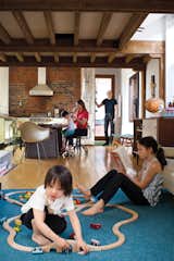 The house’s open-plan layout encourages the entire family to hang out together, even while partaking in different activities. The durable area rug, made from carpet tiles by InterfaceFLOR, is the ideal base for both reading and playing with trains, as Luka, three, demonstrates.