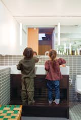In the bathroom, the twins take advantage of a custom-built Corian sink and wooden base with integrated step when it’s time to wash up.