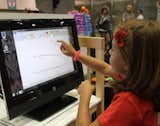 A youngster tries out the HP Touchsmart technology, which allows kids to draw right onscreen.