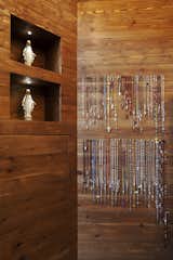 The shop is small in size, about 350 square feet, and a tacit elegance runs throughout. Simple recesses in the wall become display cases for religious icons and rosaries hang from minimalist pegs. Very little has been done to the surface of the wooden wall and the beauty of the natural grain shines through.