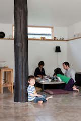 Dining Room, Concrete Floor, and Table Kaz-ma holds up the charred post while the rest of the family attends to affairs at the sunken table.  Search “11 all wood dining areas” from A Piece of Home
