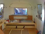 Brandes and Area 63 Productions designed this custom built-in platform sofa bed for the back of the Airstream. The lower platform pulls out and swings up on special hinges to turn the sofa into a queen size bed.