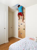The 2 Bar House by Feldman Architecture includes a secret play area above the kids’ rooms. To access the space, the children clamber up climbing holds purchased from a local sporting goods store.