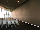 Hadid's building was commissioned in 1991 and designed to house five trucks in the large space shown here. The wall panels on the right slide open and allowed trucks to move in and out of the structure. Eight months after completion, however, the fire station was closed; the local town had created its own station, which was large enough to serve the factory. The curators of the Vitra Design Museum had apparently been hankering for more space and quickly moved the permanent chair collection, formerly on display in the Gehry building, to Hadid's Fire Station. This move enabled the curators to develop the museum's program of temporary, traveling exhibits, which Vitra is now known for around the world.