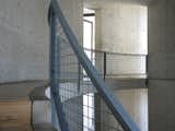 The interior of the angular building is filled with beautiful curved spaces in a simple palette of metal, concrete, wood, and glass.