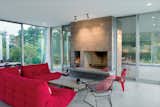 Magenta Togo sofas by Ligne Roset, a red Eames molded plywood chair, and wire Bertoia Diamond chair provide seating around the hearth.