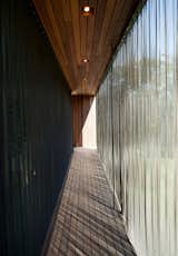 When extended, the metal-mesh curtain wall deflects the sunlight to mitigate the internal temperature of the structure. Similar energy-efficient gestures include geothermal heating and cooling, shading and venting systems, solar panels, and organic finishes and materials.  Photo 4 of 7 in Green Sustainable Home in Montauk