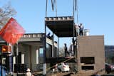 Here's one of the outdoor covered deck modules being lowered into place adjacent to the fireplace.  Photo 12 of 26 in Building a Prefab House by Jaime Gillin