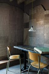 Dining Room, Table, Chair, and Pendant Lighting In a corner of the warehouse, the Heathrow limestone clads the walls.  Search “limestone” from Protect and Conserve