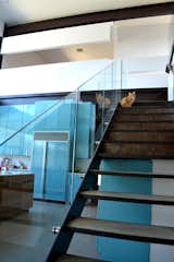 The steel-framed stair with concrete treads and glass guardrail makes a nice perch for the family cat to take in views of the lake and check out what's cooking in the kitchen. Photo by J.C. Schmeil.