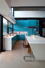 Kitchen Lacquered turquoise cabinets are topped by white quartzite countertops. Photo by Brian Mihealsick.  Photo 7 of 12 in Lakeside House in Texas