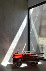The concrete retaining wall at the back of the living room and dining area registers the passage of the day through a constantly changing play of light and shadow. Photo by J.C. Schmeil.