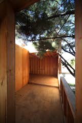 An outdoor deck connects the two guest bedrooms while Monterey pine branches poke into the deck space.