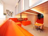 The kitchen and dining area and is surrounded by orange steps that function as seating. The dugout allows for a second level used for the bedrooms, which are housed in a polycarbonate "lightbox."
