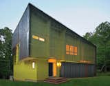 Tuned into its sylvan setting, this affordable green home in Hillsborough, North Carolina, is a modern take on the surrounding centuries-old structures. The bright green paint on its facade contrasts with the Cor-Ten steel cladding.