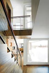 The house's L shape permits a considerable courtyard, and plenty of space for lounging behind the rain screen. The stairs sit at the intersection of the two volumes and lead down into the more social of the two: the dining room, living room, and music room.