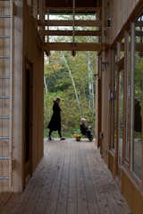 Outdoor, Wood Patio, Porch, Deck, and Large Patio, Porch, Deck What else is the porch good for? Tricycle races, of course.  Photo 7 of 60 in Kirby Road by Sidd Kashyap from Four Friends Joined Forces to Realize This Idyllic Forest Retreat Outside Toronto