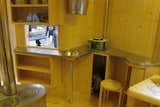 The "kitchen" is comprised of a stainless-steel worktop, a steel basin for melting snow, containers for staples, and a shelf for a camping stove.