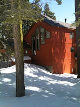 Amidst the brown natural tones of the surrounding cabins, this orange-red exterior pops. The contrasting charcoal trim and coordinated art in the window pull the whole thing together.