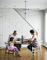 At right, the family dines at a mid-century walnut table found on eBay, 

seated at a mix of new and antique 

Wishbone chairs by Hans Wegner.