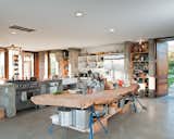This family home in Sebastopol, in the northern California wine country, had to be completely accessible, since one of the children, Ian, was in a wheelchair. The solution was to create an open-plan space with smooth concrete floors, and a massive slab of cypress perched atop sawhorses that provides storage for pots and pans.  Photo 7 of 11 in Dwell's Coolest Kitchens by Jaime Gillin