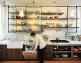 For this San Francisco kitchen remodel, designer Larissa Sand installed custom-built textured glass panels that roll on blackened steel tracks. The translucent finish and back lighting abstract the stored items, creating a clean composition (even when it's a mess).  Photo 9 of 11 in Dwell's Coolest Kitchens by Jaime Gillin