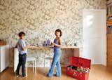 Simon and Eva Luna play in front of a wall covered in Daks wallpaper from Walnut.
