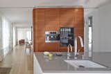 The kitchen features Miele and Bosch appliances surrounded by oak flooring from Bois Ditton; the shelves are walnut.