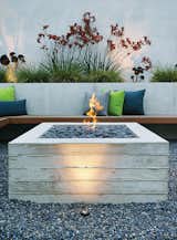 A cantilevered ipe bench hugs a custom board-formed concrete fire pit.